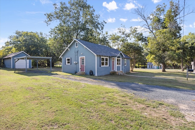 view of front of house with a carport, a garage, a front yard, and an outdoor structure