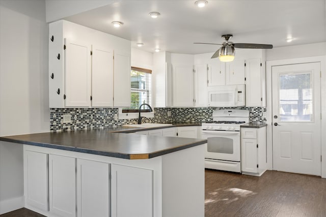 kitchen featuring kitchen peninsula, white appliances, sink, and white cabinets