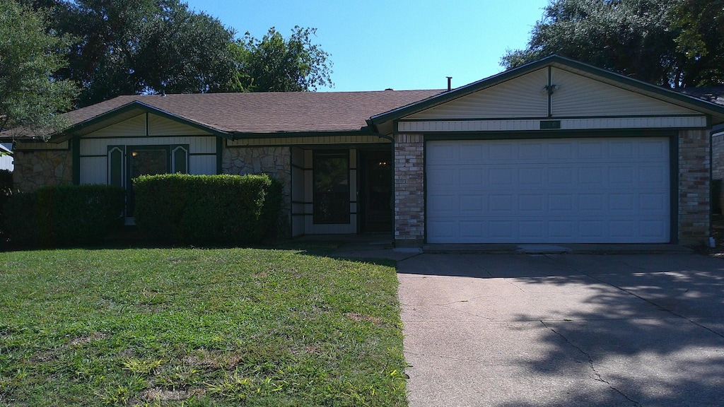 ranch-style home featuring a garage and a front yard