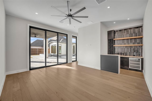 bar featuring beverage cooler and light wood-type flooring