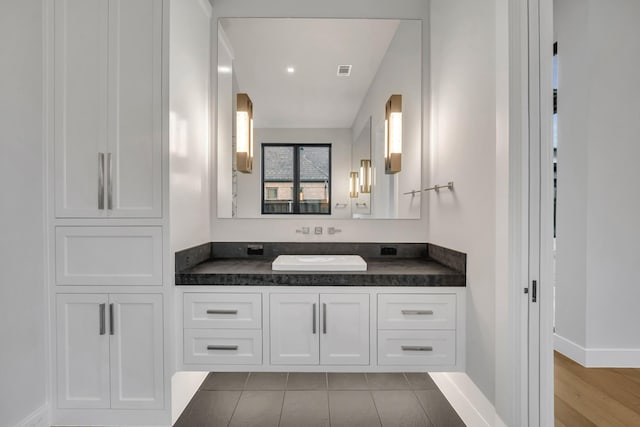 bathroom with vanity, lofted ceiling, and tile patterned flooring