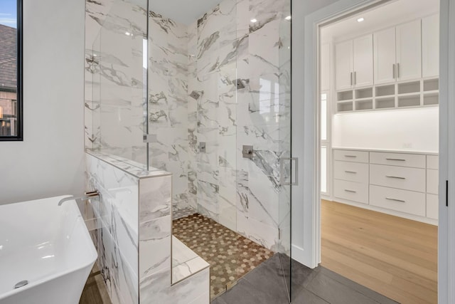 bathroom with independent shower and bath and hardwood / wood-style floors