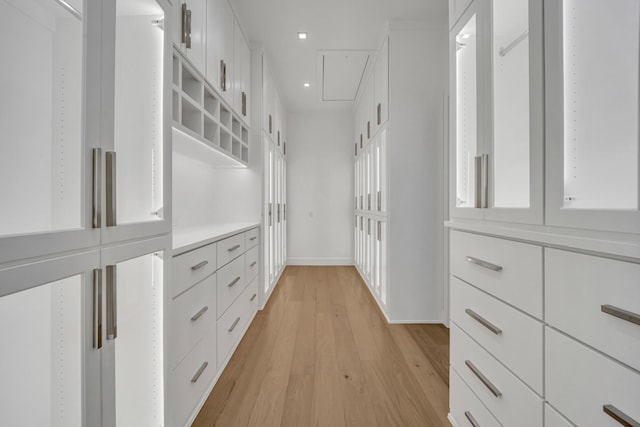 walk in closet with light hardwood / wood-style flooring