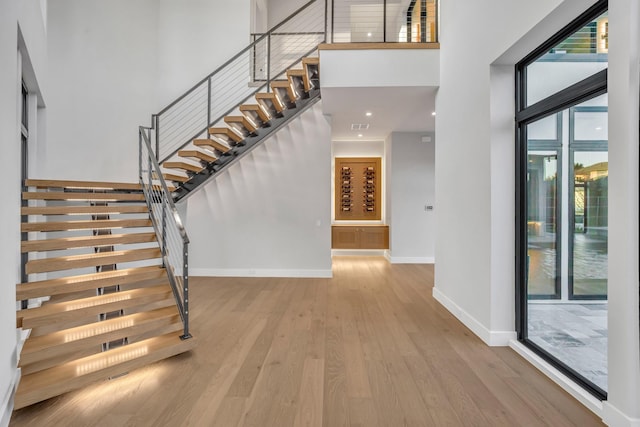 interior space with a towering ceiling and hardwood / wood-style floors