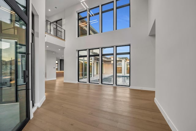 spare room featuring hardwood / wood-style floors and a high ceiling