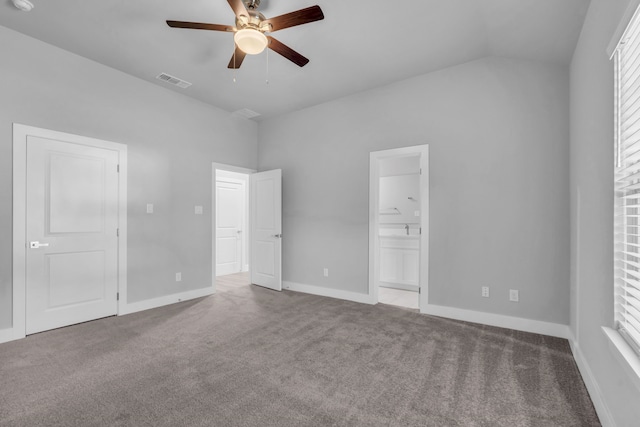 unfurnished bedroom with ceiling fan, lofted ceiling, connected bathroom, and carpet