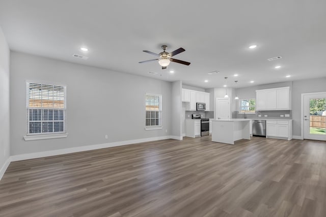 unfurnished living room featuring ceiling fan and hardwood / wood-style floors