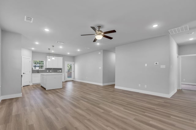 unfurnished living room featuring ceiling fan and light hardwood / wood-style flooring