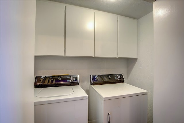 laundry room featuring cabinets, a textured ceiling, and washing machine and dryer