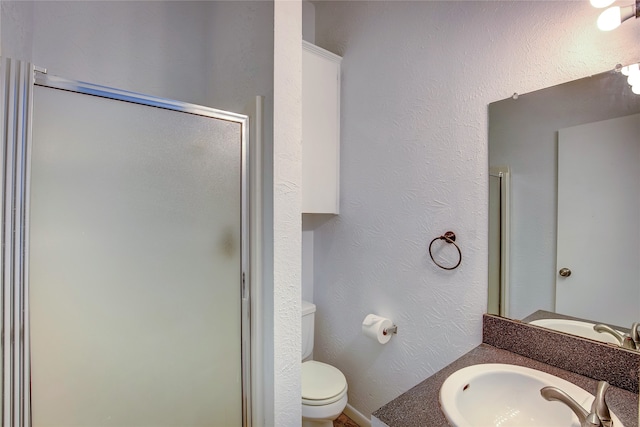 bathroom with walk in shower, vanity, and toilet