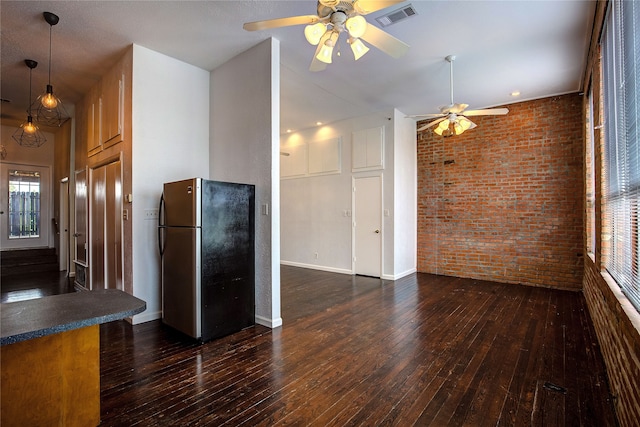 kitchen with ceiling fan, brick wall, stainless steel refrigerator, and dark hardwood / wood-style flooring