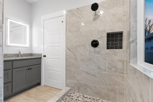 bathroom featuring tiled shower and vanity