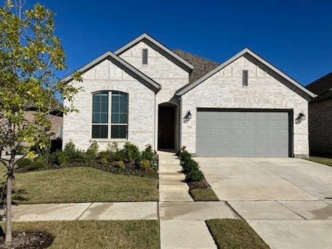 french country home featuring a garage and a front yard