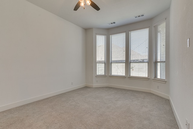 carpeted spare room with ceiling fan