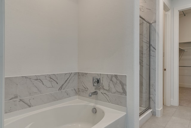 bathroom with tile patterned flooring and separate shower and tub