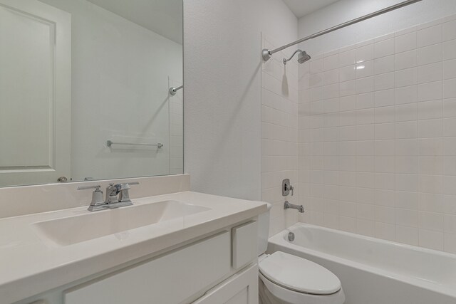 full bathroom featuring toilet, vanity, and tiled shower / bath