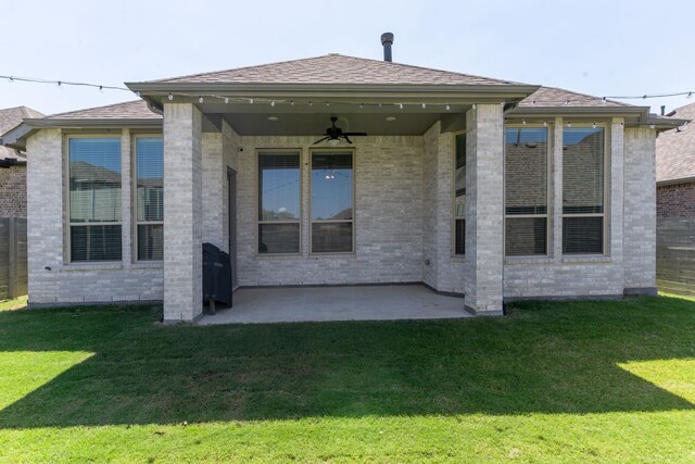 rear view of house featuring ceiling fan, a patio, and a yard