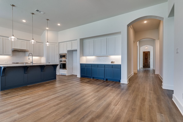 kitchen featuring white cabinets, light hardwood / wood-style floors, and tasteful backsplash