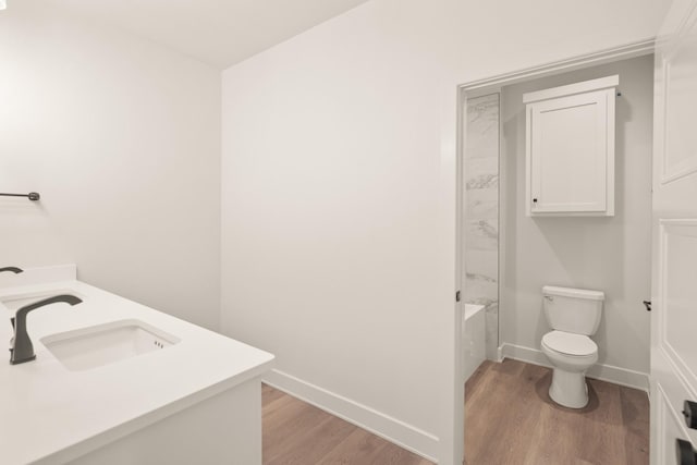 bathroom with hardwood / wood-style flooring, vanity, and toilet