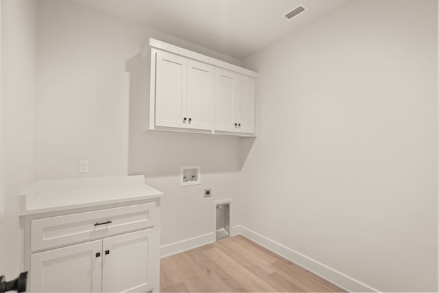 clothes washing area featuring cabinets, hookup for a washing machine, light hardwood / wood-style floors, and hookup for an electric dryer