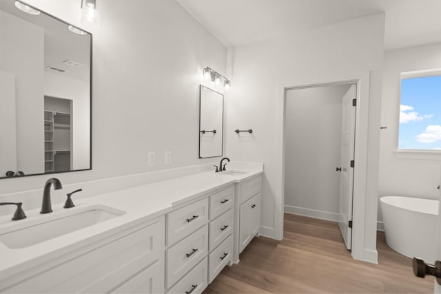 bathroom featuring vanity, a bathtub, and wood-type flooring