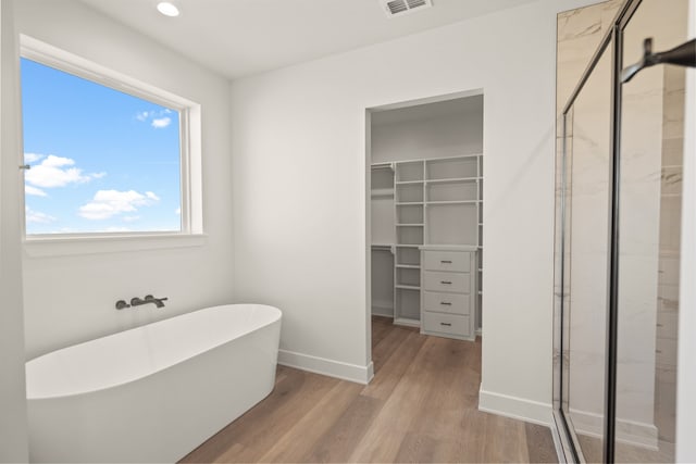 bathroom featuring separate shower and tub and hardwood / wood-style floors