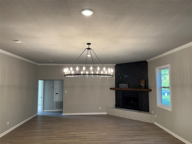 interior space featuring a textured ceiling, wood-type flooring, a fireplace, and ornamental molding