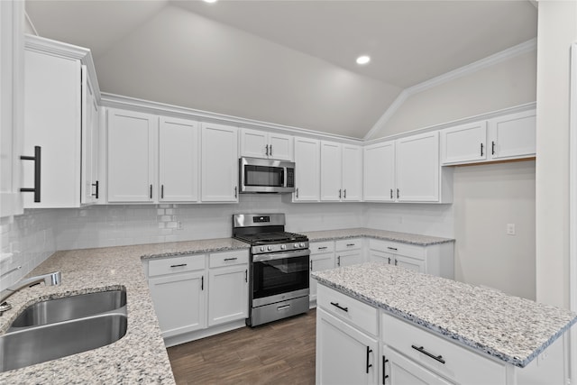 kitchen featuring sink, lofted ceiling, white cabinetry, stainless steel appliances, and dark hardwood / wood-style flooring