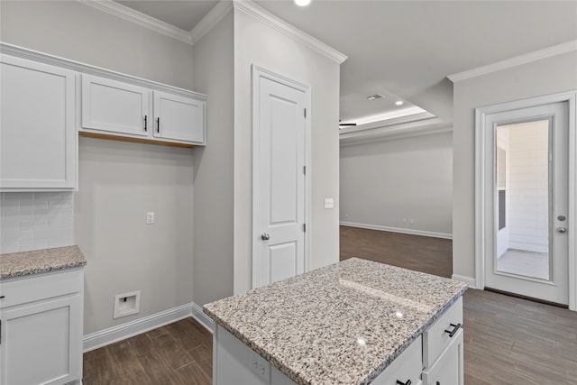 kitchen with white cabinets, light stone countertops, ornamental molding, and tasteful backsplash