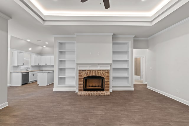 unfurnished living room featuring light wood-type flooring, crown molding, ceiling fan, and a brick fireplace