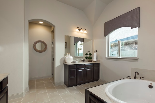 bathroom with vanity, lofted ceiling, shower with separate bathtub, and tile patterned floors