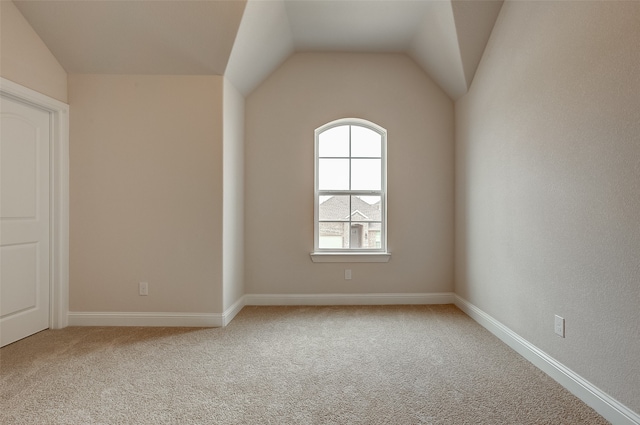 unfurnished room featuring vaulted ceiling and carpet floors