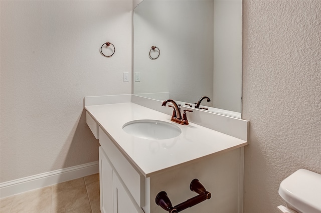 bathroom featuring vanity, tile patterned flooring, and toilet