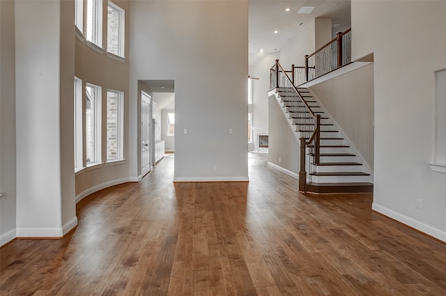 entryway featuring a towering ceiling, hardwood / wood-style floors, and a healthy amount of sunlight