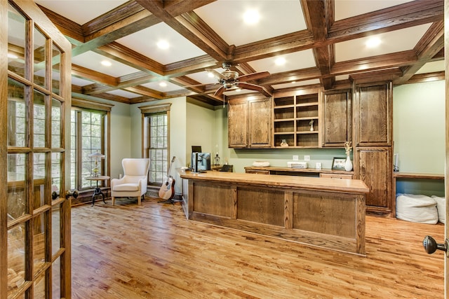 interior space with light wood-type flooring, beamed ceiling, coffered ceiling, ornamental molding, and ceiling fan