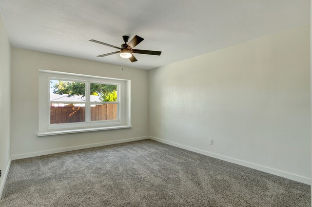 carpeted spare room featuring ceiling fan