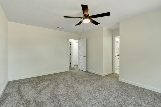 unfurnished bedroom with ceiling fan, connected bathroom, and light carpet