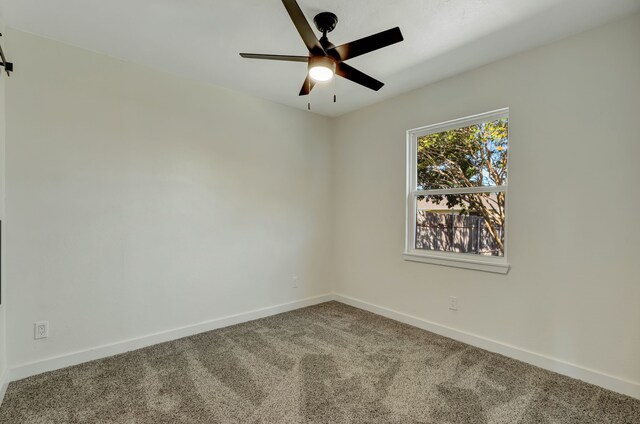 carpeted spare room featuring ceiling fan