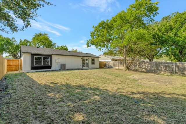 back of house featuring a yard and central AC