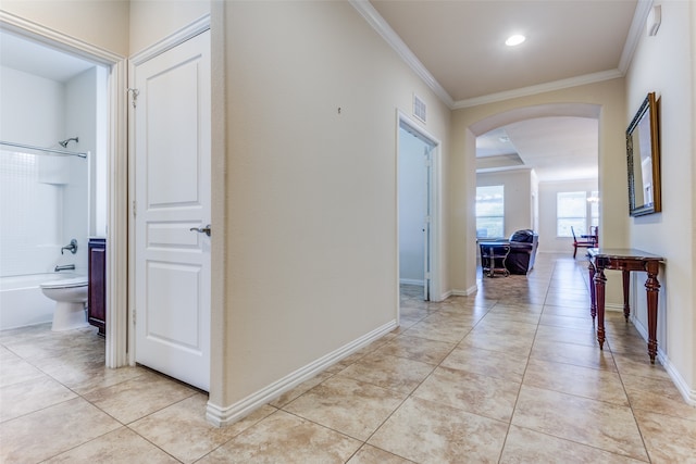 corridor with light tile patterned floors and crown molding