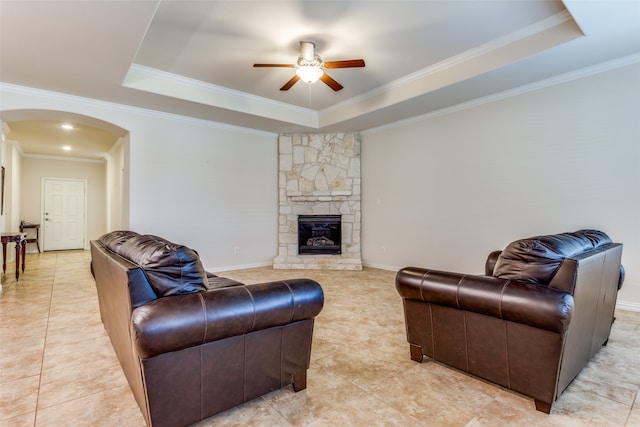 living room with a raised ceiling and ornamental molding