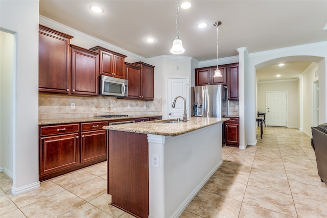 kitchen with sink, a kitchen island with sink, ornamental molding, light stone countertops, and appliances with stainless steel finishes