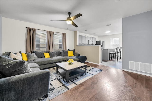 living room with light wood-type flooring and ceiling fan