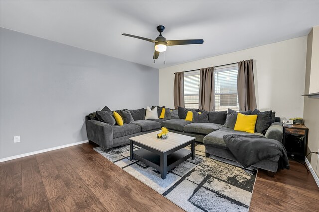 living room featuring dark wood-type flooring and ceiling fan