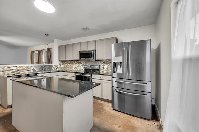 kitchen with sink, a kitchen island, hanging light fixtures, stainless steel appliances, and decorative backsplash