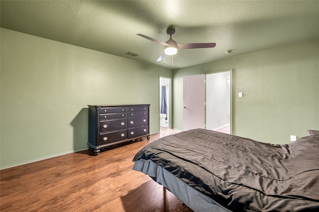 bedroom with a textured ceiling, hardwood / wood-style flooring, and ceiling fan