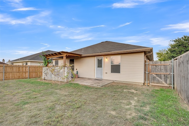 rear view of property with a yard and a patio