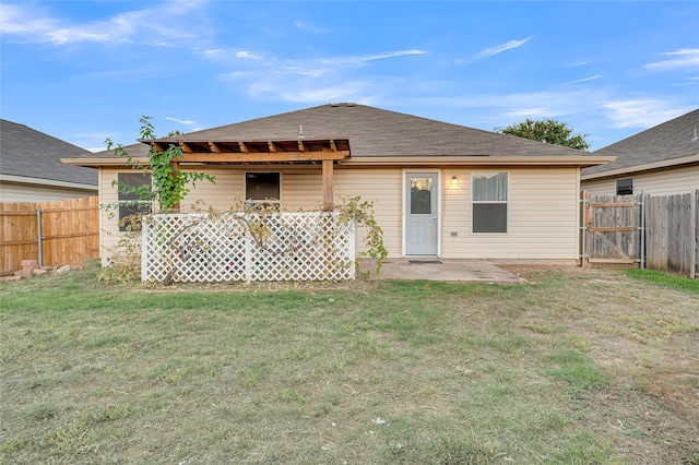 rear view of property with a yard and a patio