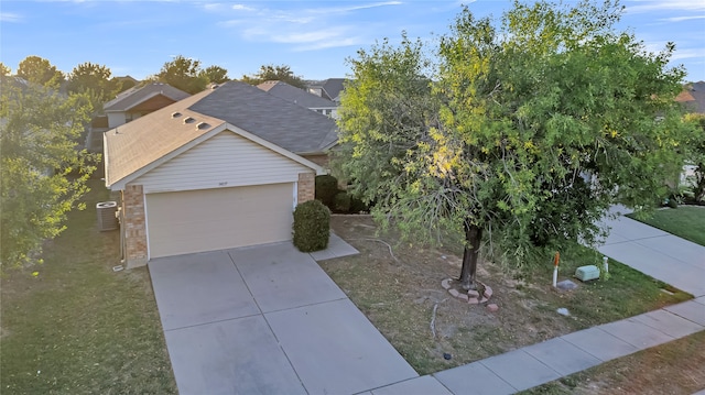 view of property hidden behind natural elements with central AC and a front yard