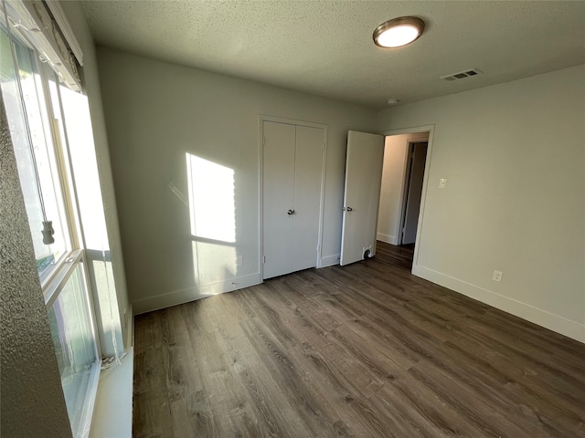 unfurnished bedroom with a textured ceiling and hardwood / wood-style floors